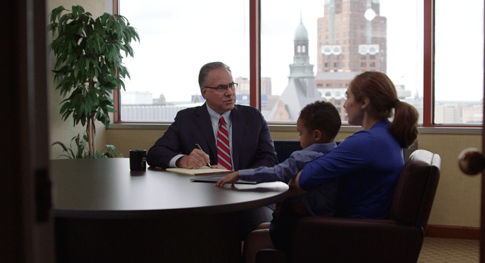 Attorney Thadd Llaurado counsels a client who is holding her child