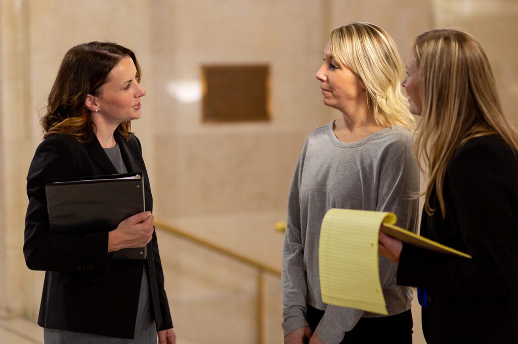 Milwaukee defective drug injury lawyers advise their client outside a courtroom