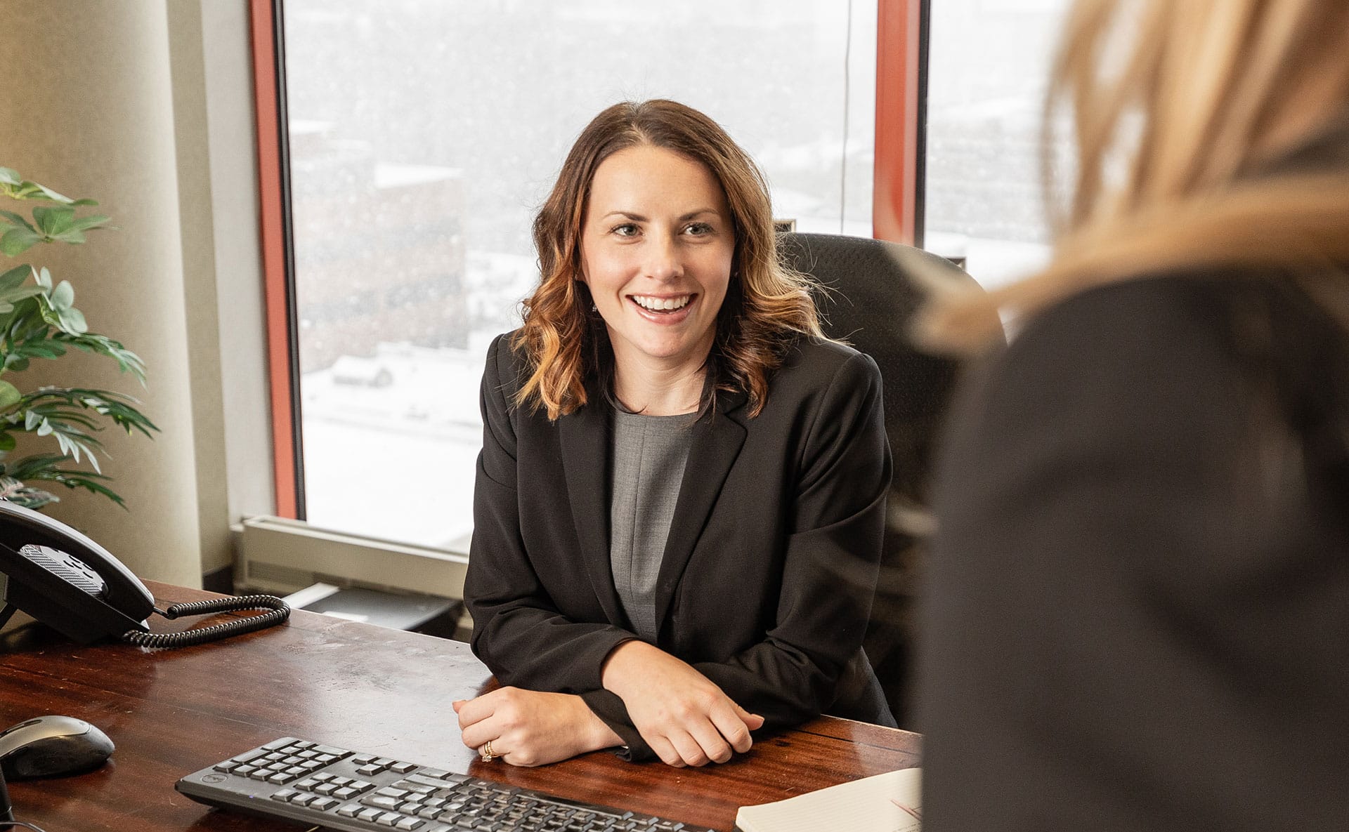 A good personal injury lawyer smiling at her desk